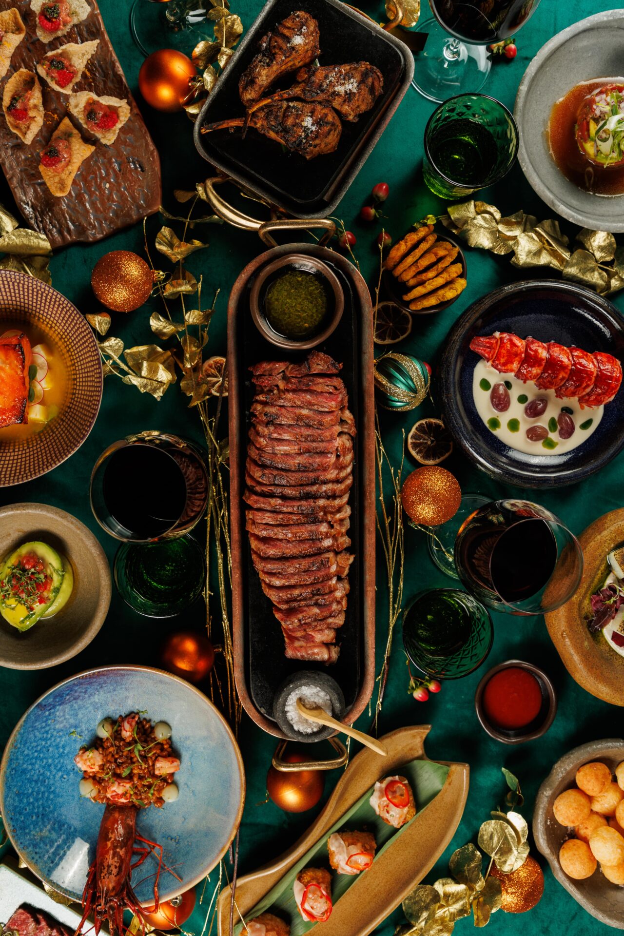 Christmas dining spread with steak, lobster, and gourmet sides.