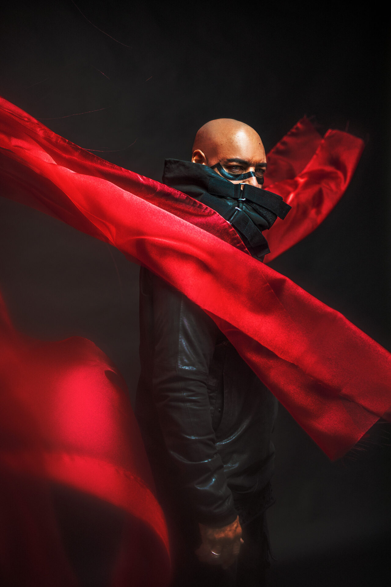Dj Roger Sanchez standing on his side covered by a red scarf