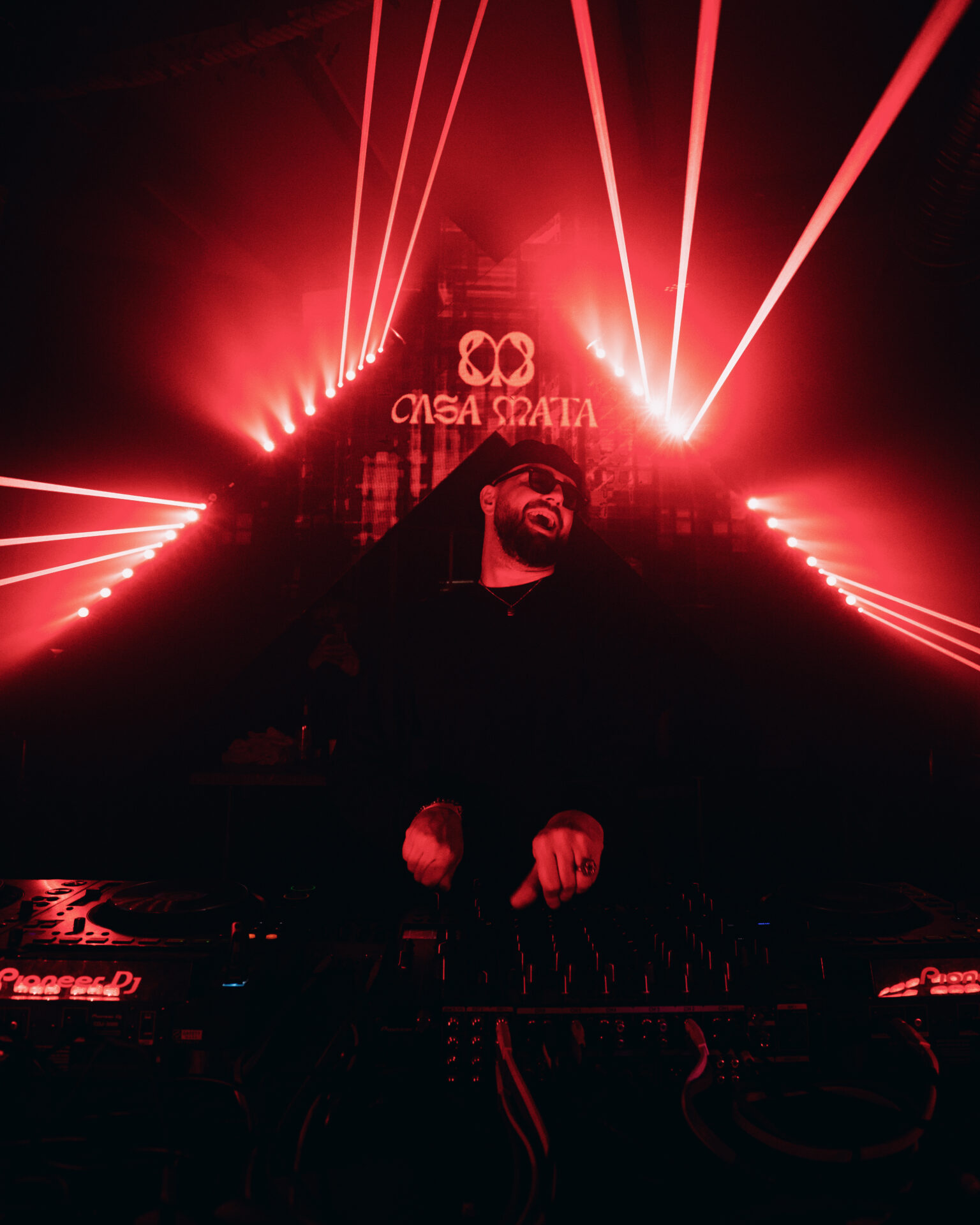 Casa Mata djing on the decks with red light system behind him